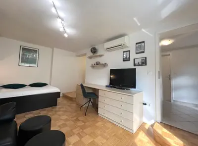 a bedroom with a bed and a desk with a television at Luxury Studio Apartments in Ljubljana