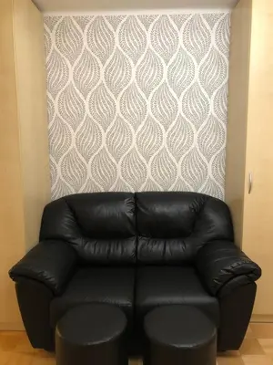 a black leather couch sitting in front of a wall at Luxury Studio Apartments in Ljubljana