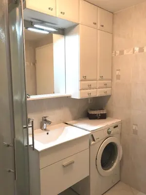 a bathroom with a sink and a washing machine at Luxury Studio Apartments in Ljubljana