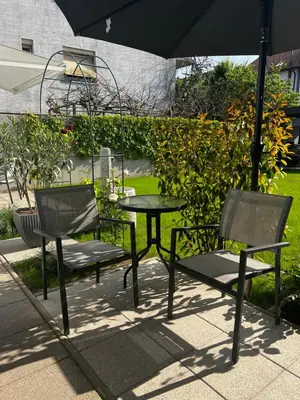 two chairs and a table with an umbrella at Luxury Studio Apartments in Ljubljana