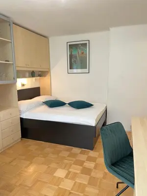 a small bedroom with a bed and a chair at Luxury Studio Apartments in Ljubljana