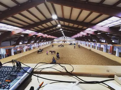 an overhead view of a large arena with people riding horses at Ranch Marina in Koče