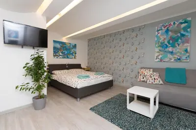 a bedroom with a bed and a couch and a tv at Big yard in Ljubljana