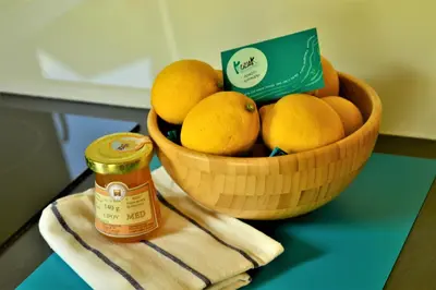 a bowl of lemons on a table with a jar of honey at Sleeping with the bees Kozjak in Kobarid