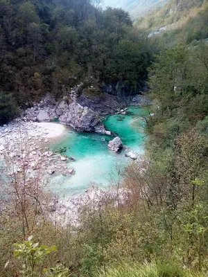 a river with green water and rocks in a valley at Sleeping with the bees Kozjak in Kobarid