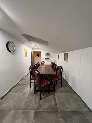 a dining room with a table and chairs and a clock at apartma 