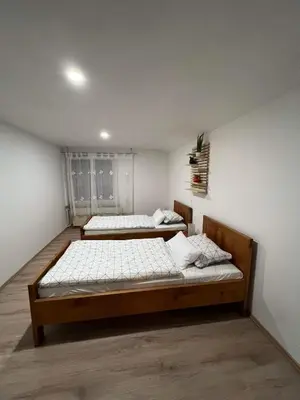 two beds in a room with white walls at apartma 