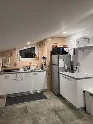 a kitchen with white cabinets and a refrigerator at apartma 
