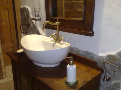 a bathroom with a white sink on a wooden table at ETNO HOUSE GOSTECE- Suite with Finnish sauna in Mozirje