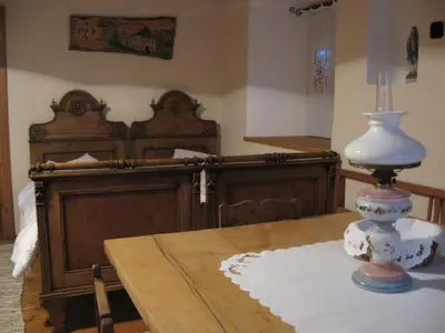 a room with a bed and a table with a lamp at ETNO HOUSE GOSTECE- Suite with Finnish sauna in Mozirje