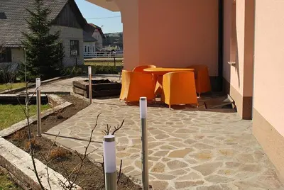 a patio with some orange chairs and a table at Apartments Lavric in Nova Vas
