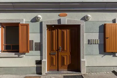 a building with a brown door and two windows at Mountain Charm in Kranjska Gora
