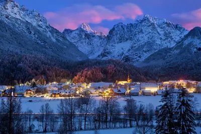 a small town in the mountains at night with snow at Mountain Charm in Kranjska Gora