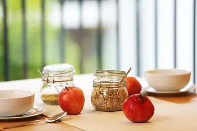 a table with two apples and jars of food at Apartments and Rooms Bernik in Kranjska Gora