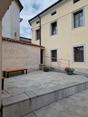 a patio with a bench next to a building at Apartma in soba Vipavski Križ in Ajdovščina