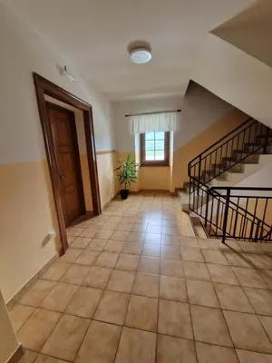 an empty hallway with stairs and a potted plant at Apartma in soba Vipavski Križ in Ajdovščina