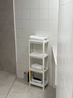 a white shelf in a white tiled bathroom at Industrial Studio 6 in Ljubljana