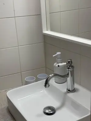 a bathroom sink with a faucet and a mirror at Industrial Studio 6 in Ljubljana