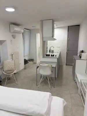 a white kitchen with two chairs and a table in it at Industrial Studio 6 in Ljubljana