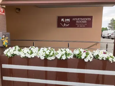 a fence with flowers on it in front of a building at Apartments-rooms Vogrinec in Ptuj