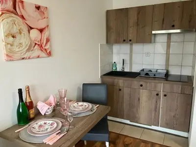 a kitchen with a table with plates and wine glasses at Apartments-rooms Vogrinec in Ptuj