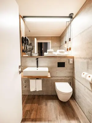 a bathroom with a sink and a toilet and a mirror at Hotel City Maribor in Maribor