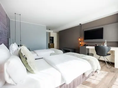a bedroom with two beds and a desk at Hotel City Maribor in Maribor