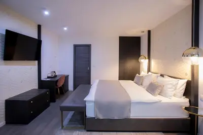 a bedroom with a large white bed and a desk at House Klasika - Adults Only in Bled