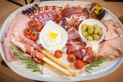a plate of food with different types of meat and vegetables at House Klasika - Adults Only in Bled