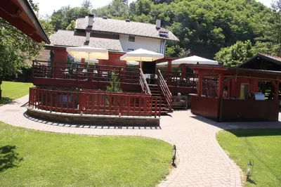 a patio with tables and umbrellas in front of a house at B&B Pri Peclju in Podgrad