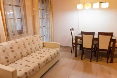 a living room with a couch and a table and chairs at Vila Silva Marija Apartments in Pišece