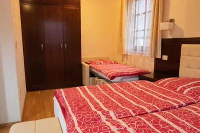 a bedroom with two beds and a cabinet and a window at Vila Silva Marija Apartments in Pišece