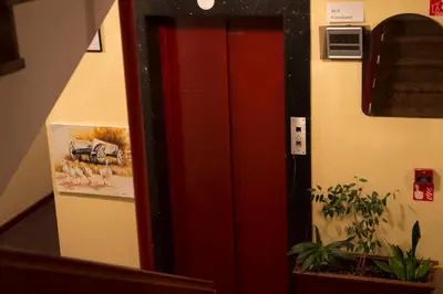 a red elevator in a room with a picture on the wall at Hotel Krona Domžale in Domžale