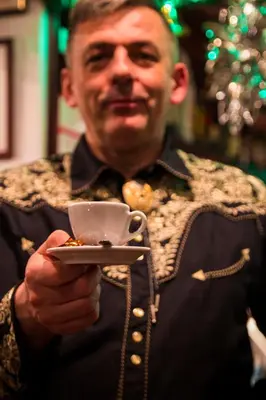 a man holding a cup and a plate of food at Hotel Krona Domžale in Domžale