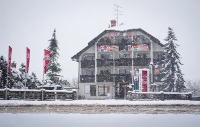 a large building in the snow with flags at Hotel Krona Domžale in Domžale