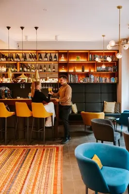 a man standing at a bar in a restaurant at Hotel Mrak in Ljubljana