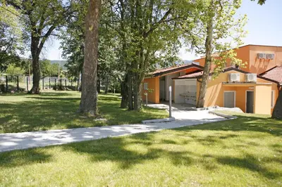 a house in a yard with trees and a driveway at Garni Hotel Siesta in Nova Gorica