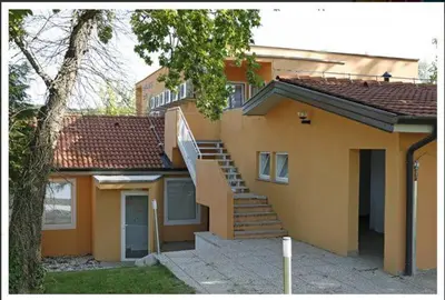 a yellow house with a staircase in front of it at Garni Hotel Siesta in Nova Gorica