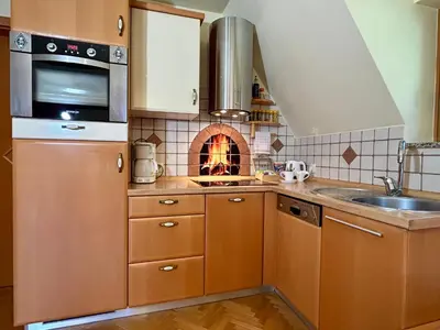 a kitchen with wooden cabinets and a brick oven at Apartment Crystal Rose in Kranjska Gora