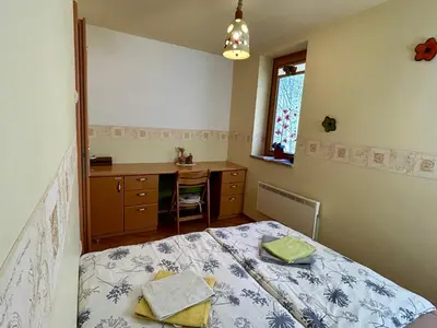 a bedroom with a bed and a desk and a window at Apartment Crystal Rose in Kranjska Gora