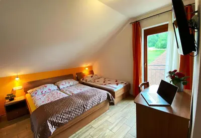 a bedroom with two beds and a laptop on a desk at Guesthouse Mesec Zaplana in Vrhnika