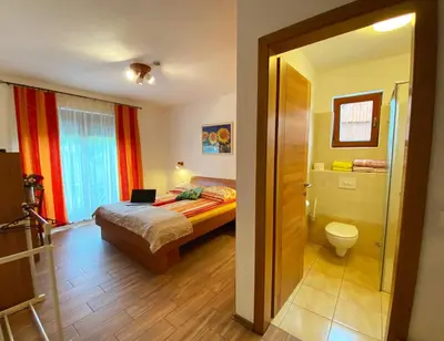 a bedroom with a bed and a bathroom with a toilet at Guesthouse Mesec Zaplana in Vrhnika