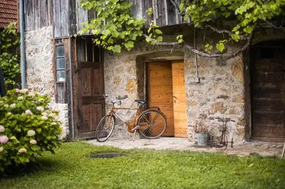 a bike parked next to a building with a wooden door at Vintage House Podliparska in Fara