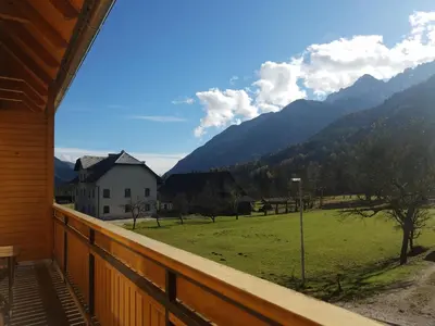 a balcony with a view of a field and mountains at Sun and Spa Apartment in Kranjska Gora
