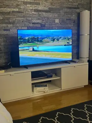 a flat screen tv sitting on a stand in a living room at Sun and Spa Apartment in Kranjska Gora