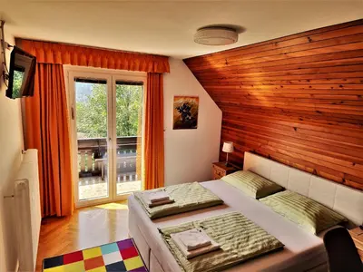 a bedroom with a large bed and a window at Tourist house Capricorn in Bled
