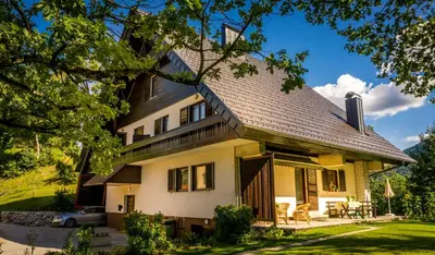 a yellow house with a gambrel roof at Tourist house Capricorn in Bled