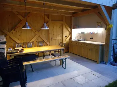 a room with a wooden table and a kitchen at Green Garden Apartment in Bled