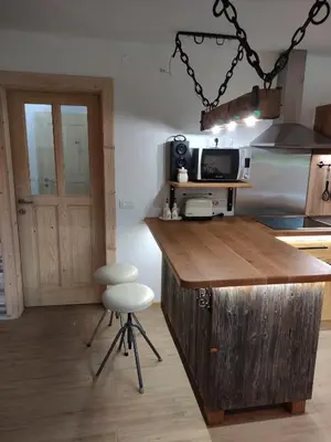 a kitchen with a counter with a microwave and a stool at Green Garden Apartment in Bled