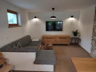 a living room with a couch and a tv at Green Garden Apartment in Bled